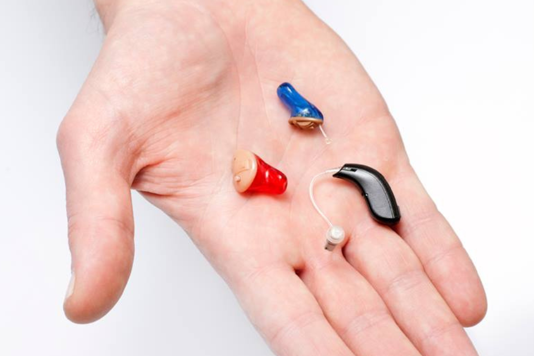 Palm displayed open with multiple hearing aid options in various sizes